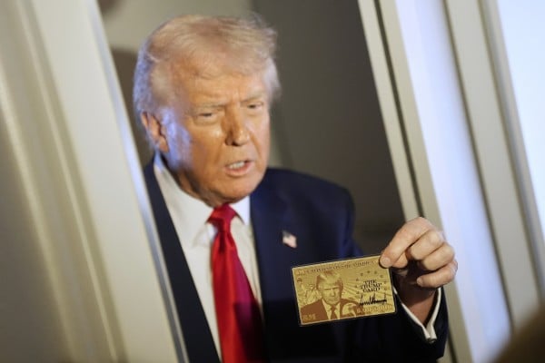 US President Donald Trump holds up the original US$5 million gold card as he speaks to reporters while on board Air Force One, on April 3. Photo: AP US President Donald Trump holds up the original US$5 million gold card as he speaks to reporters while on board Air Force One, on April 3. Photo: AP