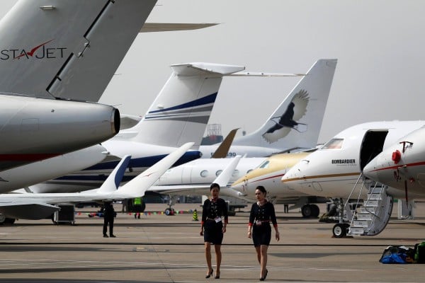 Two crew members walk past business jets in Shanghai. Photo: AFP Two crew members walk past business jets in Shanghai. Photo: AFP