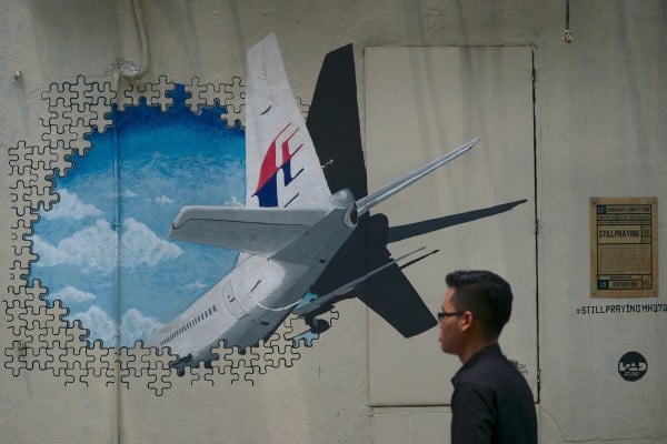 A man walks pasts a mural representing the missing Malaysia Airlines flight MH370 at an alley in Shah Alam, near Kuala Lumpur. Photo: AFP A man walks pasts a mural representing the missing Malaysia Airlines flight MH370 at an alley in Shah Alam, near Kuala Lumpur. Photo: AFP
