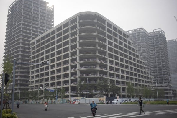People pass by half-finished buildings in Beijing. China’s property market has been mired in a downturn since 2021. Photo: EPA-EFE People pass by half-finished buildings in Beijing. China’s property market has been mired in a downturn since 2021. Photo: EPA-EFE