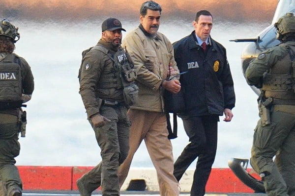 Nicolas Maduro in handcuffs after landing at a Manhattan helipad, escorted by heavily armed federal agents as he and his wife make their way into an armoured car en route to a federal courthouse. Photo: TNS Nicolas Maduro in handcuffs after landing at a Manhattan helipad, escorted by heavily armed federal agents as he and his wife make their way into an armoured car en route to a federal courthouse. Photo: TNS