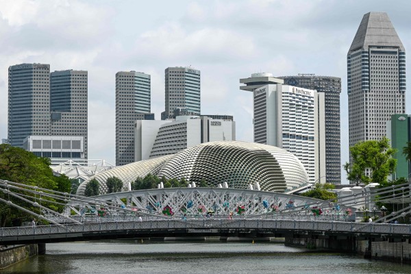 People walk across the Anderson bridge in the backdrop of the skyline in Singapore. The city state is poised to continue leading the charge in attracting FDI into the region, observers say. Photo: AFP