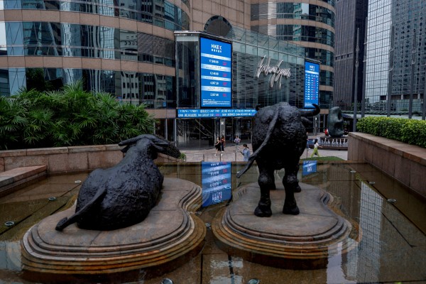 Bull statues sit in front of screens showing stock prices outside Exchange Square in Hong Kong on August 18, 2023. Photo: Reuters