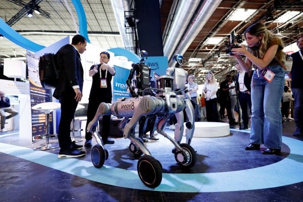 Visitors take pictures of Unitree robots at a fair in Paris. Photo: Reuters