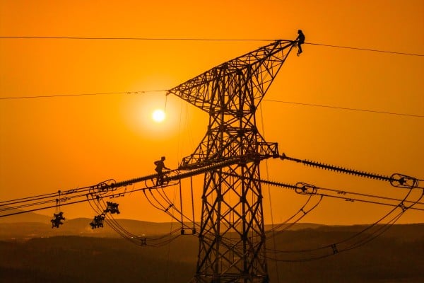 Construction workers build a power transmission line in China’s central Anhui province. China is ramping up investment in its power grid amid surging demand from the country’s artificial intelligence industry. Photo: Xinhua Construction workers build a power transmission line in China’s central Anhui province. China is ramping up investment in its power grid amid surging demand from the country’s artificial intelligence industry. Photo: Xinhua