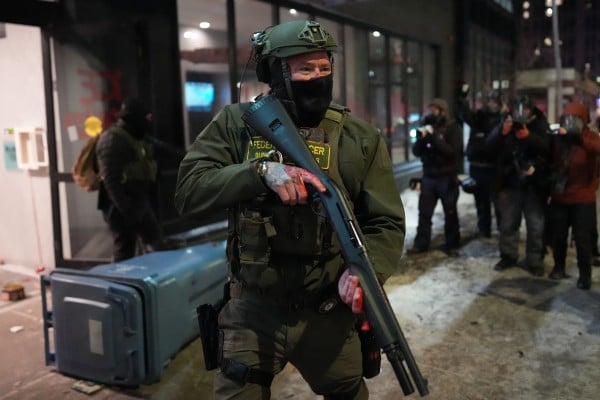 A federal agent stands guard near a hotel during a protest against immigration enforcement operations in Minneapolis. Photo: AP A federal agent stands guard near a hotel during a protest against immigration enforcement operations in Minneapolis. Photo: AP