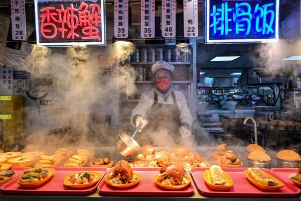 A food seller prepares dishes at a restaurant in Shanghai on January 21. Photo: AFP A food seller prepares dishes at a restaurant in Shanghai on January 21. Photo: AFP