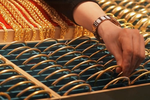 A shopkeeper adjusts gold bracelets at a jewellery mall in Shanghai, China, on January 27. Photo: Reuters
A shopkeeper adjusts gold bracelets at a jewellery mall in Shanghai, China, on January 27. Photo: Reuters