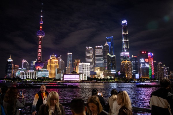 People walk at the Bund by the Huangpu river with skyscrapers of the Lujiazui financial district in the background, in Shanghai. Photo: Reuters