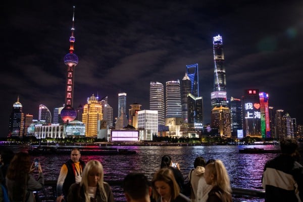 People walk at the Bund by the Huangpu river with skyscrapers of the Lujiazui financial district in the background, in Shanghai. Photo: Reuters People walk at the Bund by the Huangpu river with skyscrapers of the Lujiazui financial district in the background, in Shanghai. Photo: Reuters