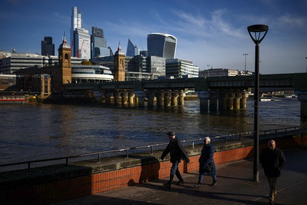 People walk past skyscrapers and office buildings in London. Photo: AFP