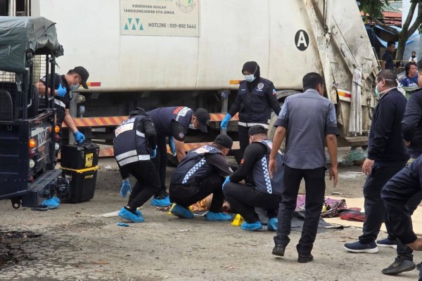 Malaysian police officers investigate a crime scene in Indah Permai, Kota Kinabalu. Photo: The Star
