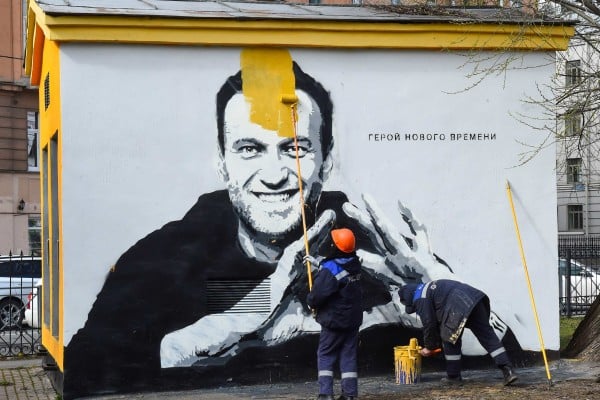 A worker paints over graffiti of jailed Kremlin critic Alexei Navalny in St Petersburg in April 2021. The inscription reads: “The hero of the new times.” Photo: AFP A worker paints over graffiti of jailed Kremlin critic Alexei Navalny in St Petersburg in April 2021. The inscription reads: “The hero of the new times.” Photo: AFP