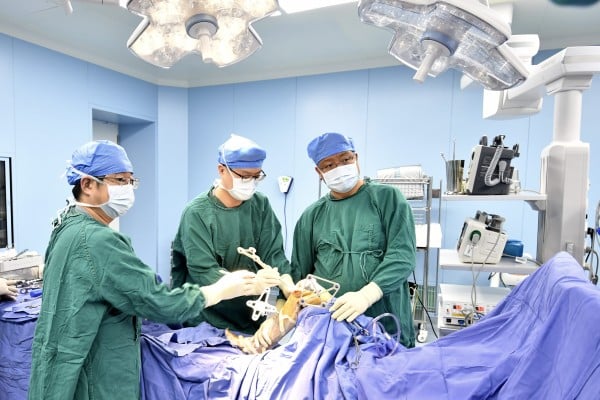 Specialists perform orthopaedic surgery using a robotic system at the Tongzhou branch of Beijing Anzhen Hospital in Beijing on February 3. Photo: Xinhua Specialists perform orthopaedic surgery using a robotic system at the Tongzhou branch of Beijing Anzhen Hospital in Beijing on February 3. Photo: Xinhua