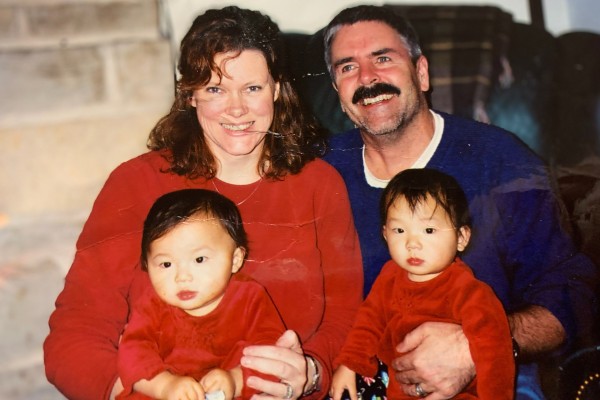 Phoebe McChesney, left, with her twin sister and parents in the US, after their adoption from Hunan, China. Photo: Handout