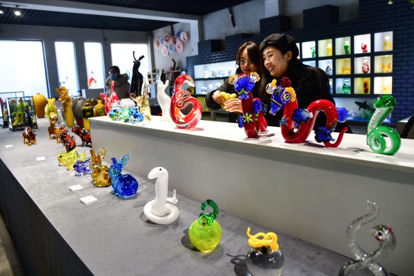 Customers choose colored glaze snake handicrafts for the coming Chinese New Year, the Year of Snake, in Xiye Colored Glaze Studio in Boshan district, Zibo city, Shandong province, China, on Jan. 9, 2025. With a long history of colored glaze, Boshan is regarded as China’s Hometown of Colored Glaze and has 12 colored glaze enterprises and 65 art studios. (Xinhua)
 新华社照片，淄博（山东），2025年1月9日
    1月9日，消费者在淄博市博山区西冶工坊展销厅内挑选蛇年主题琉璃工艺品。
    春节临近，山东省淄博市博山区的琉璃生产企业推出众多蛇年主题创意琉璃制品，受到市场青睐。博山区被誉为“中国琉璃之乡“，琉璃生产历史悠久，当地已发展琉璃生产企业12家、工作室65个。
    新华社记者 朱峥 摄