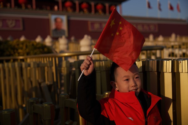 A child waves a Chinese flag near Tiananmen Gate in Beijing on February 19. China’s leadership is calling for local-level cadres across the country to do work that “benefits the people”. Photo: AP