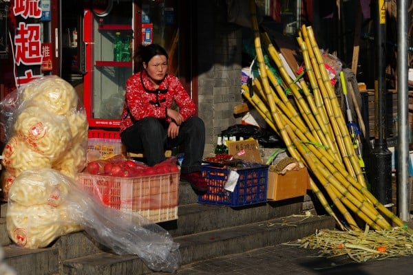 A vendor sits at the doorway to her store in Beijing on February 18. China’s leadership is pivoting towards people-centric, consumption-led economic growth. Photo: Getty Images A vendor sits at the doorway to her store in Beijing on February 18. China’s leadership is pivoting towards people-centric, consumption-led economic growth. Photo: Getty Images