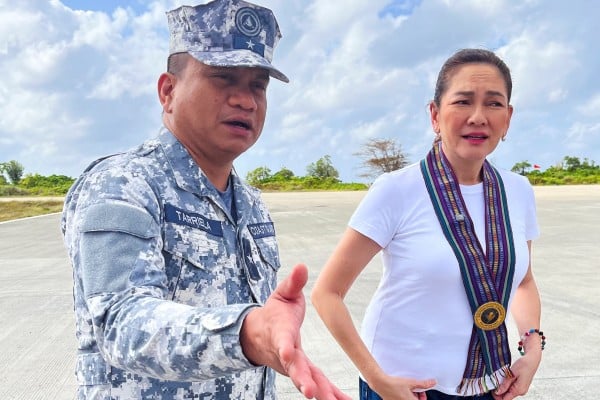 Philippine Coast Guard spokesman Jay Tarriela gestures beside Senator Risa Hontiveros during a visit to Philippine-occupied Thitu island in the disputed South China Sea on February 21. Photo: Reuters Philippine Coast Guard spokesman Jay Tarriela gestures beside Senator Risa Hontiveros during a visit to Philippine-occupied Thitu island in the disputed South China Sea on February 21. Photo: Reuters