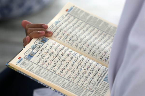 A pupil learns to read Arabic during a Koran memorisation lesson. Photo: EPA