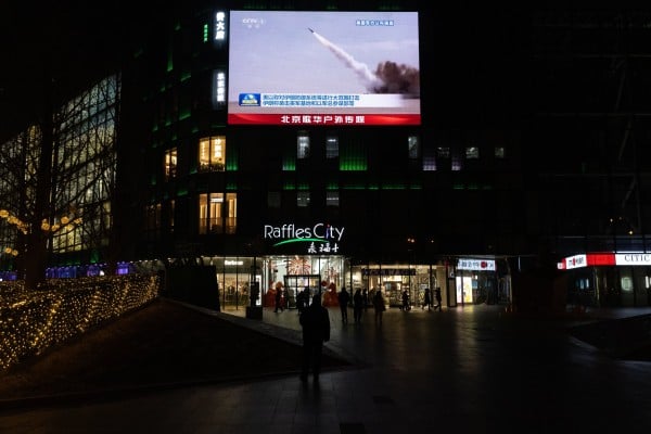 Beijing shoppers watch coverage of US-Israeli air strikes in Iran. Photo: EPA