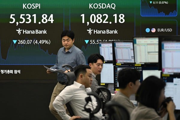 Currency dealers monitor exchange rates as an electronic screen shows South Korea’s benchmark stock index on Wednesday. Photo: AFP Currency dealers monitor exchange rates as an electronic screen shows South Korea’s benchmark stock index on Wednesday. Photo: AFP