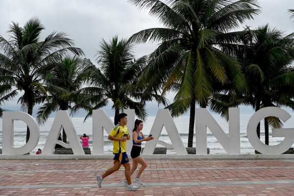 A couple runs along the seafront next to the beach in Da Nang, central Vietnam, last year. Photo: AFP