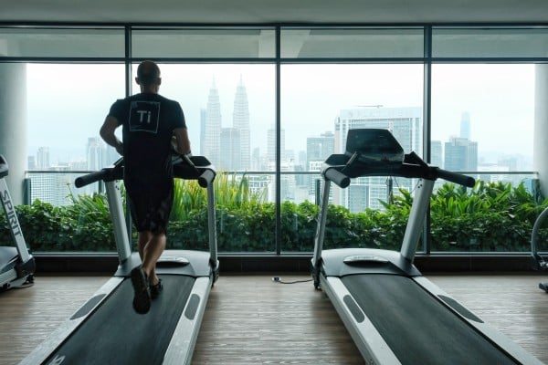A man runs on a treadmill with a view of Petronas Twin Towers in Kuala Lumpur, Malaysia. Photo: Shutterstock A man runs on a treadmill with a view of Petronas Twin Towers in Kuala Lumpur, Malaysia. Photo: Shutterstock