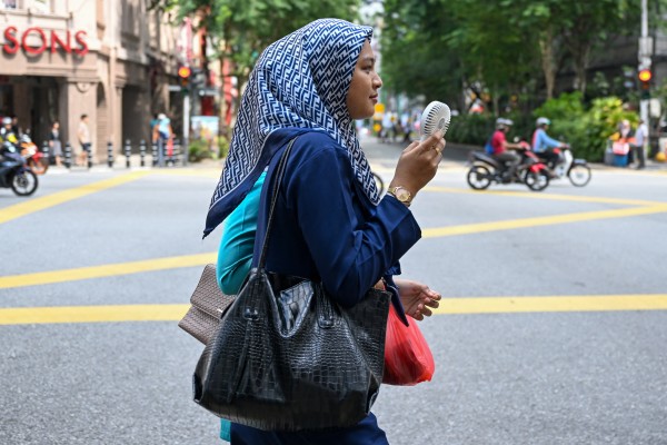 A women uses an electric fan to cool off in Kuala Lumpur, Malaysia. Photo: AFP