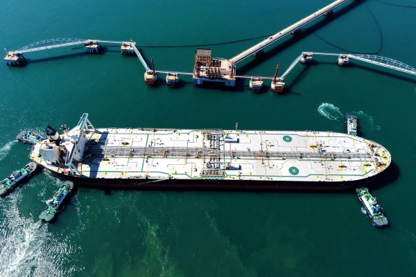 A crude oil tanker is guided to a berth at a terminal in China’s Shandong province on Saturday. Photo: AFP