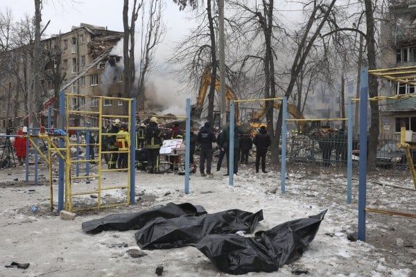 Rescuers stand near bodies retrieved from the site of a strike on a residential building in Kharkiv, northeastern Ukraine, on Saturday. Photo: EPA Rescuers stand near bodies retrieved from the site of a strike on a residential building in Kharkiv, northeastern Ukraine, on Saturday. Photo: EPA
