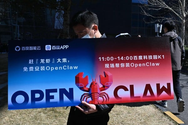 A man holds a placard featuring OpenClaw, an open-source AI assistant in Beijing on March 11. Photo: AFP A man holds a placard featuring OpenClaw, an open-source AI assistant in Beijing on March 11. Photo: AFP