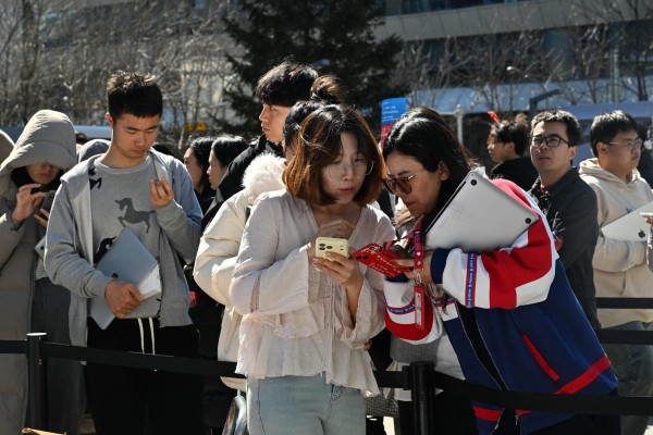 Members of the public queue to have their laptops installed with OpenClaw, an open-source AI assistant, in Beijing on March 11. Photo: AFP