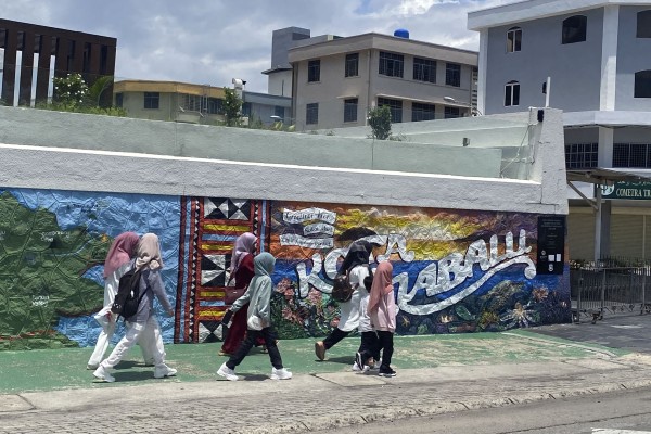 People walk past a mural in Kota Kinabalu, Sabah. Photo: Tamara Hinson