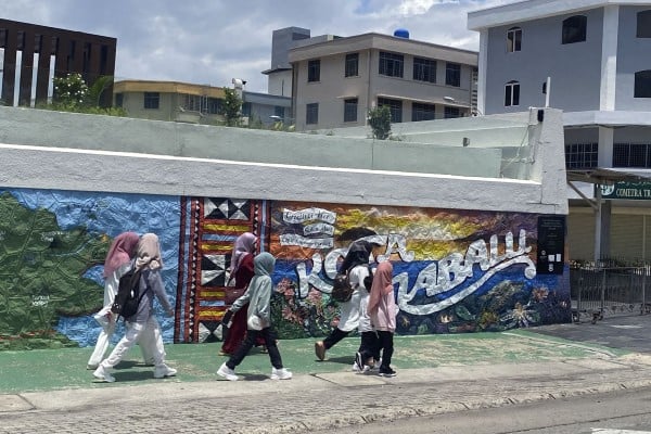 People walk past a mural in Kota Kinabalu, Sabah. Photo: Tamara Hinson People walk past a mural in Kota Kinabalu, Sabah. Photo: Tamara Hinson