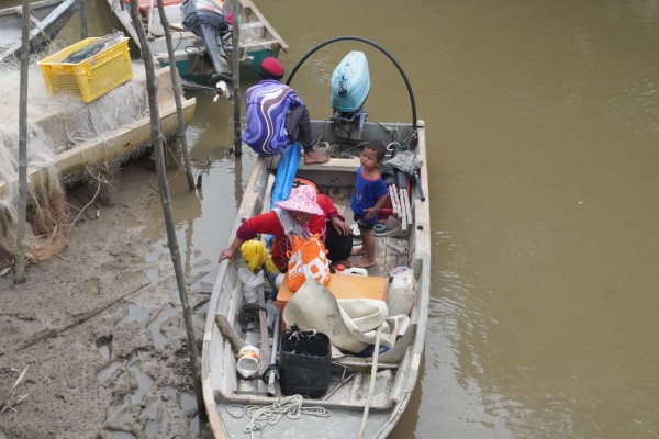 Malaysian fisherman Lingan bin Man pulls up to the jetty in Kampung Sungai Kurau with his family. Photo: Ushar Daniele