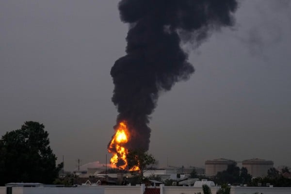 Fire and plumes of smoke rise after a drone struck a fuel tank in the United Arab Emirates on Monday. Photo: AP Fire and plumes of smoke rise after a drone struck a fuel tank in the United Arab Emirates on Monday. Photo: AP