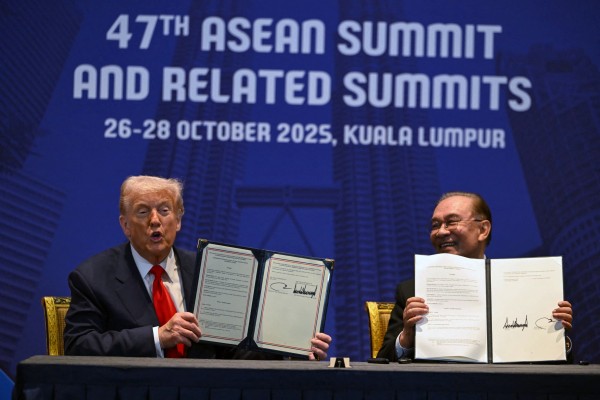 US President Donald Trump (left) and Malaysia’s Prime Minister Anwar Ibrahim hold up signed documents on a trade deal in Kuala Lumpur on October 26, 2025. Photo: AFP