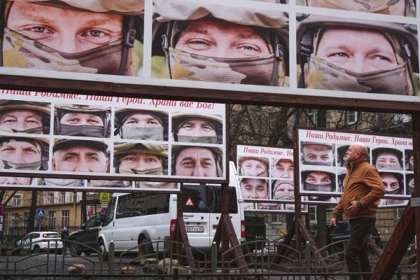 A man walks past portraits of Russian soldiers in a St Petersburg street exhibition. Photo: AP A man walks past portraits of Russian soldiers in a St Petersburg street exhibition. Photo: AP