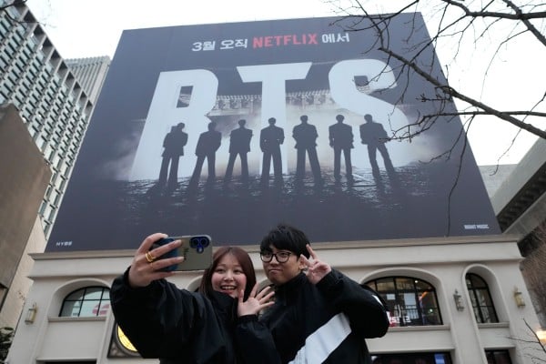 A couple takes a selfie photo near a banner promoting a comeback concert of K-pop group BTS at Gwanghwamun Square in Seoul, Wednesday, March 18, 2026. (AP Photo/Ahn Young-joon) A couple takes a selfie photo near a banner promoting a comeback concert of K-pop group BTS at Gwanghwamun Square in Seoul, Wednesday, March 18, 2026. (AP Photo/Ahn Young-joon)