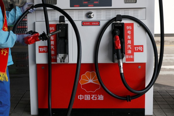 An attendant holds a petrol nozzle after refuelling a car at a petrol station in Beijing last week. China imported 159.79 million barrels of Russian crude in the first two months of the year. Photo: Reuters
