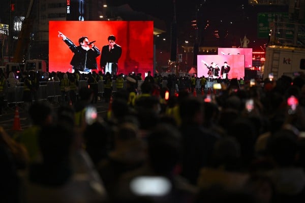 BTS fans watch the comeback concert of K-pop boy group BTS on screens at the venue in Seoul on March 21, 2026. South Korean megastars BTS reunited on March 21 for their first show in nearly four years, blowing away enormous crowds in Seoul for a K-pop extravaganza livestreamed to millions more worldwide. (Photo by Jung Yeon-je / AFP) BTS fans watch the comeback concert of K-pop boy group BTS on screens at the venue in Seoul on March 21, 2026. South Korean megastars BTS reunited on March 21 for their first show in nearly four years, blowing away enormous crowds in Seoul for a K-pop extravaganza livestreamed to millions more worldwide. (Photo by Jung Yeon-je / AFP)