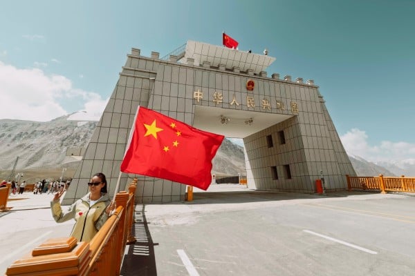A visitor takes a photo at a  China-Pakistan border crossing checkpost, high in the Karakoram Range in Xinjiang. Photo: EPA