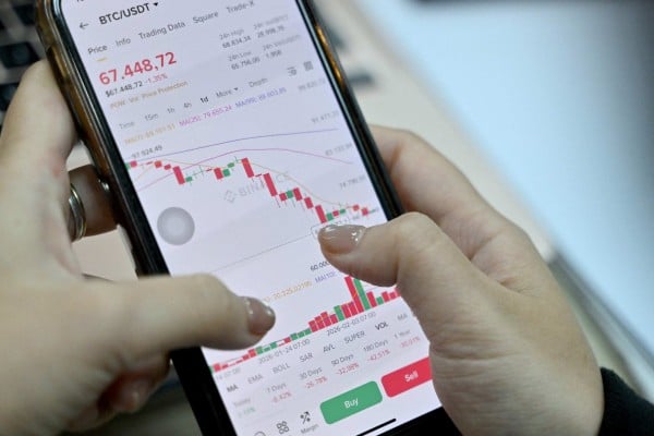 This photo taken on February 12, 2026 shows a Vietnamese cryptocurrency investor looking at the latest bitcoin values on a smartphone in Hanoi. Photo: AFP This photo taken on February 12, 2026 shows a Vietnamese cryptocurrency investor looking at the latest bitcoin values on a smartphone in Hanoi. Photo: AFP