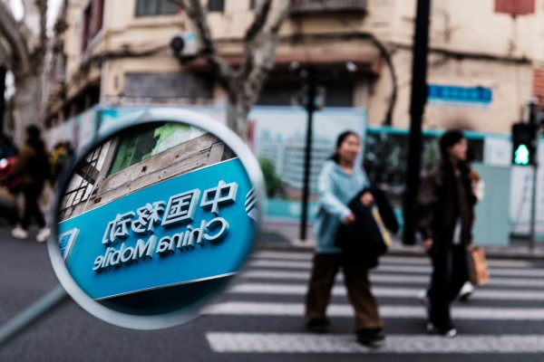 A China Mobile logo is seen in a mirror in Shanghai on March 26, 2026. Photo: EPA