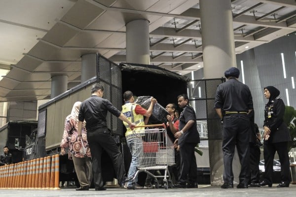 Boxes of seized goods taken from a Kuala Lumpur condominium owned by former Malaysian prime minister Najib Razak’s family are loaded into a police truck by officers in 2018. Photo: EPA-EFE
Boxes of seized goods taken from a Kuala Lumpur condominium owned by former Malaysian prime minister Najib Razak’s family are loaded into a police truck by officers in 2018. Photo: EPA-EFE