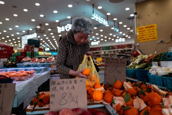 A woman selects fruit at a supermarket in Shanghai on Friday. Photo: EPA