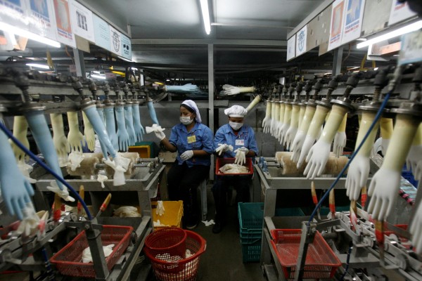 Workers collect rubber gloves at Top Glove’s factory in Klang, outside Kuala Lumpur. Photo: Reuters Workers collect rubber gloves at Top Glove’s factory in Klang, outside Kuala Lumpur. Photo: Reuters