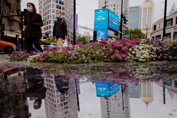People walk near a screen showing stock exchange and economic data in Shanghai on April 20, 2026. Photo: EPA People walk near a screen showing stock exchange and economic data in Shanghai on April 20, 2026. Photo: EPA