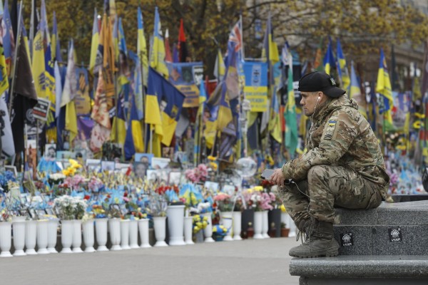 A man in military uniform sits near a makeshift memorial dedicated to the fallen Ukrainian soldiers and international volunteers in Independence Square in Kyiv, Ukraine on April 20, 2026. Photo: EPA